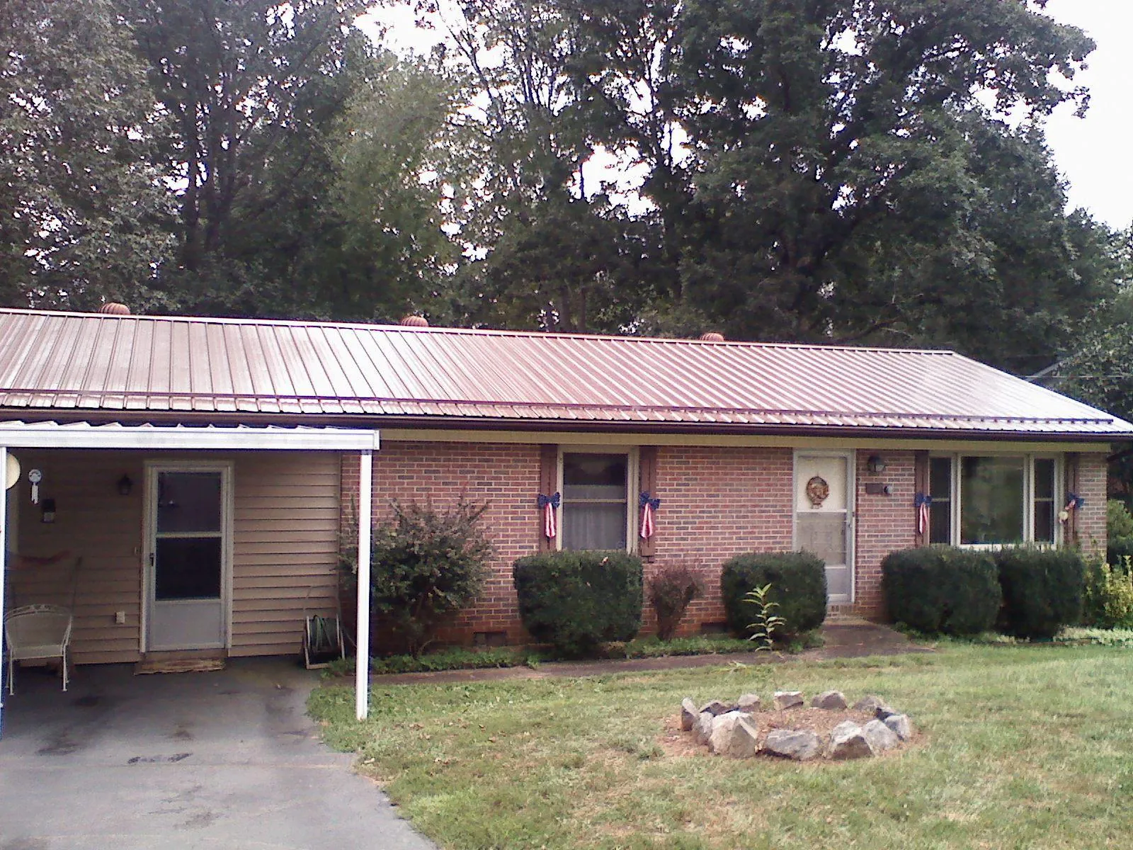 Bronze metal roof and carport on a brick ranch home — Roof Repair work by our crew in Buckner