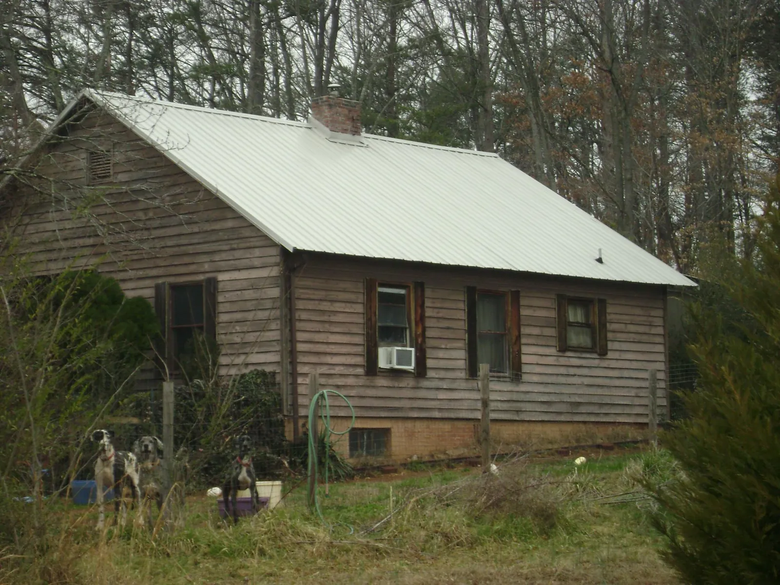 White metal roof on an old wood sided farmhouse, from a Metal Roof Installation job in Buckner